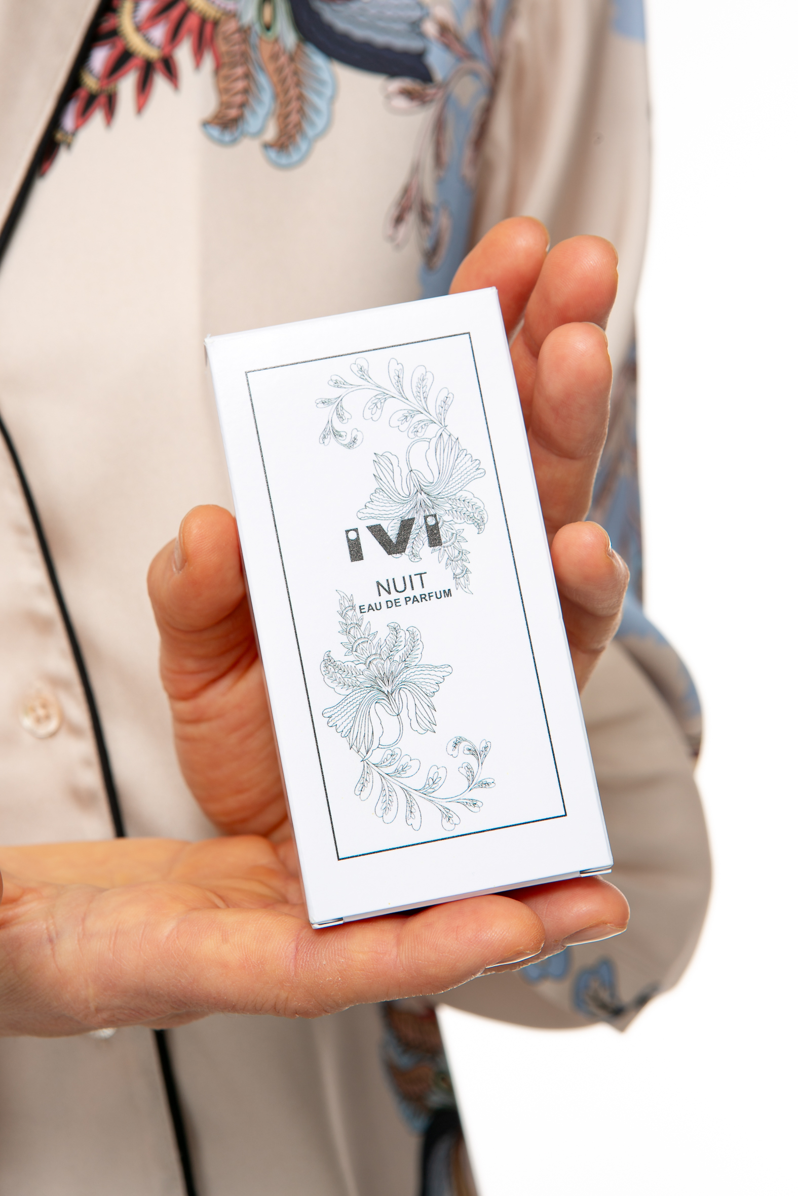 _Zusatz20237 Produktbild: Model hält die Verpackung des IVI NUIT Parfüms.