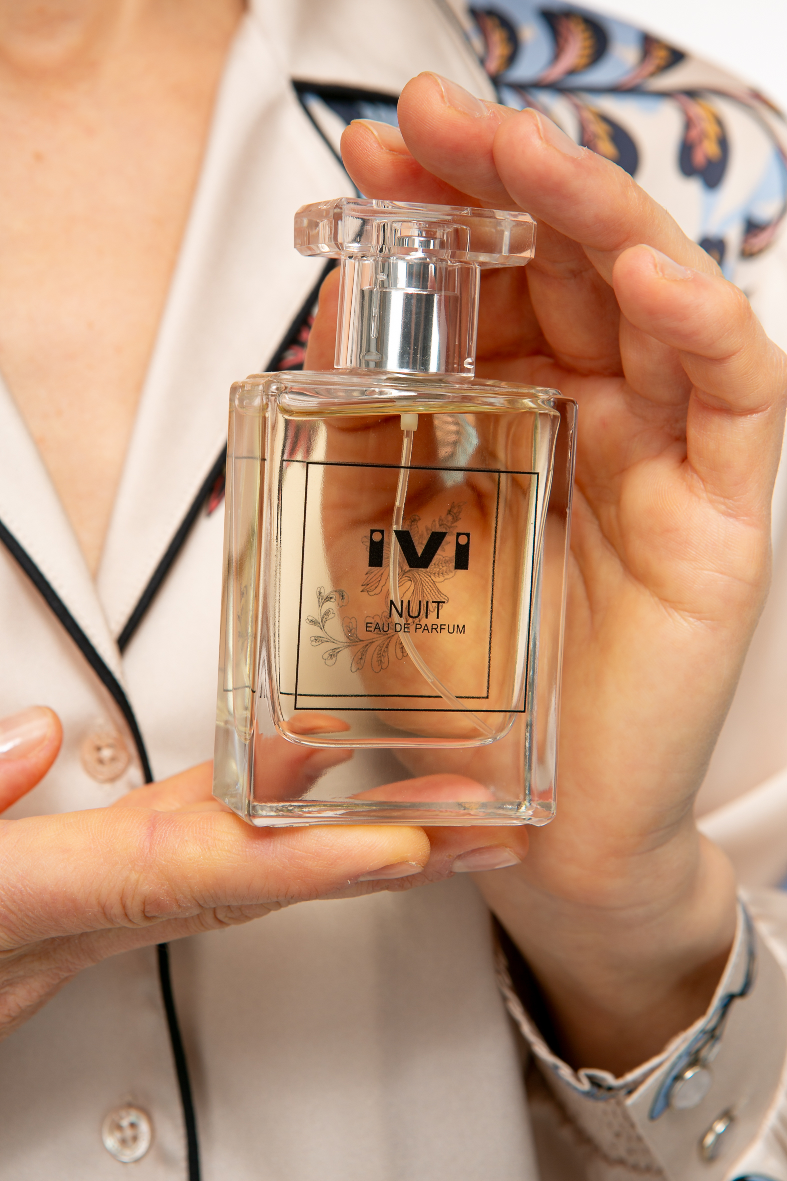 _Zusatz20243 Produktbild: Model hält das IVI NUIT Parfüm.