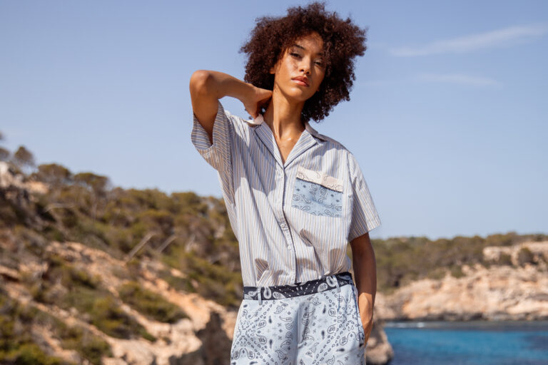 Imagebild: Model steht vor Meer und trägt BANDANA PATCH Hemdbluse mit passender Seidehose.