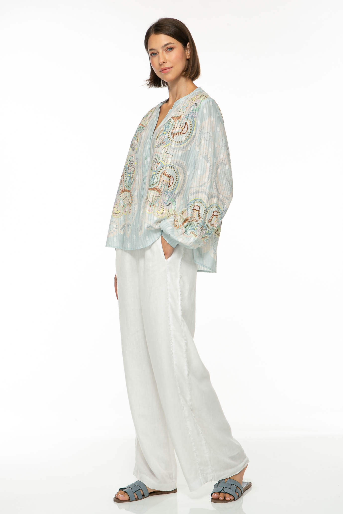 M16_1247-2 Produktbild der EMBELLISHED LACE Baumwollbluse mit floralem Print auf hellblauem Hintergrund. Bild von der Seite.
