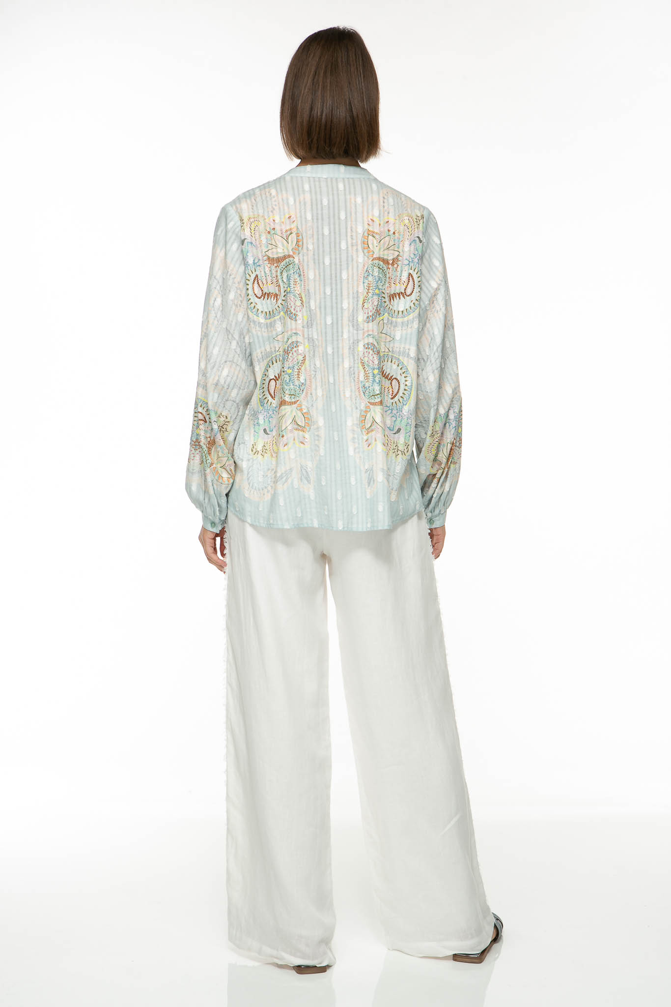 M16_1275-2 Produktbild der EMBELLISHED LACE Baumwollbluse mit floralem Print auf hellblauem Hintergrund. Bild von hinten.