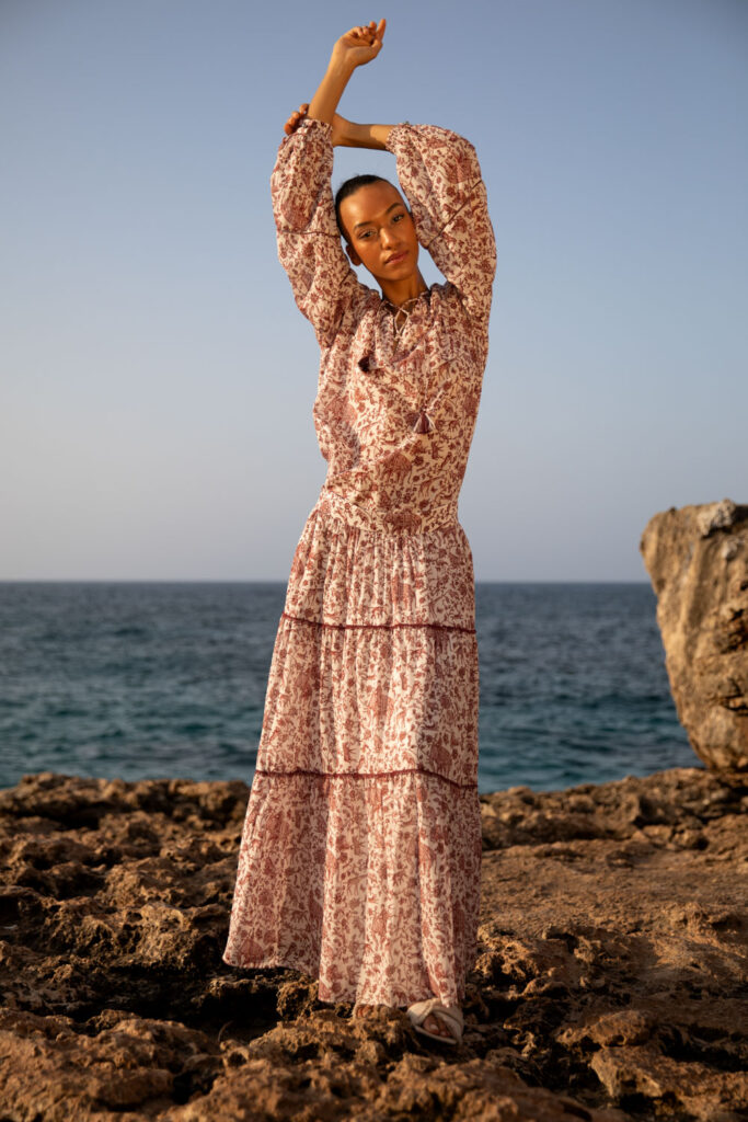 Imagebild: Model steht auf Küstenklippen vor dem Meer und trägt WILDLIFE Bluse und Rock.