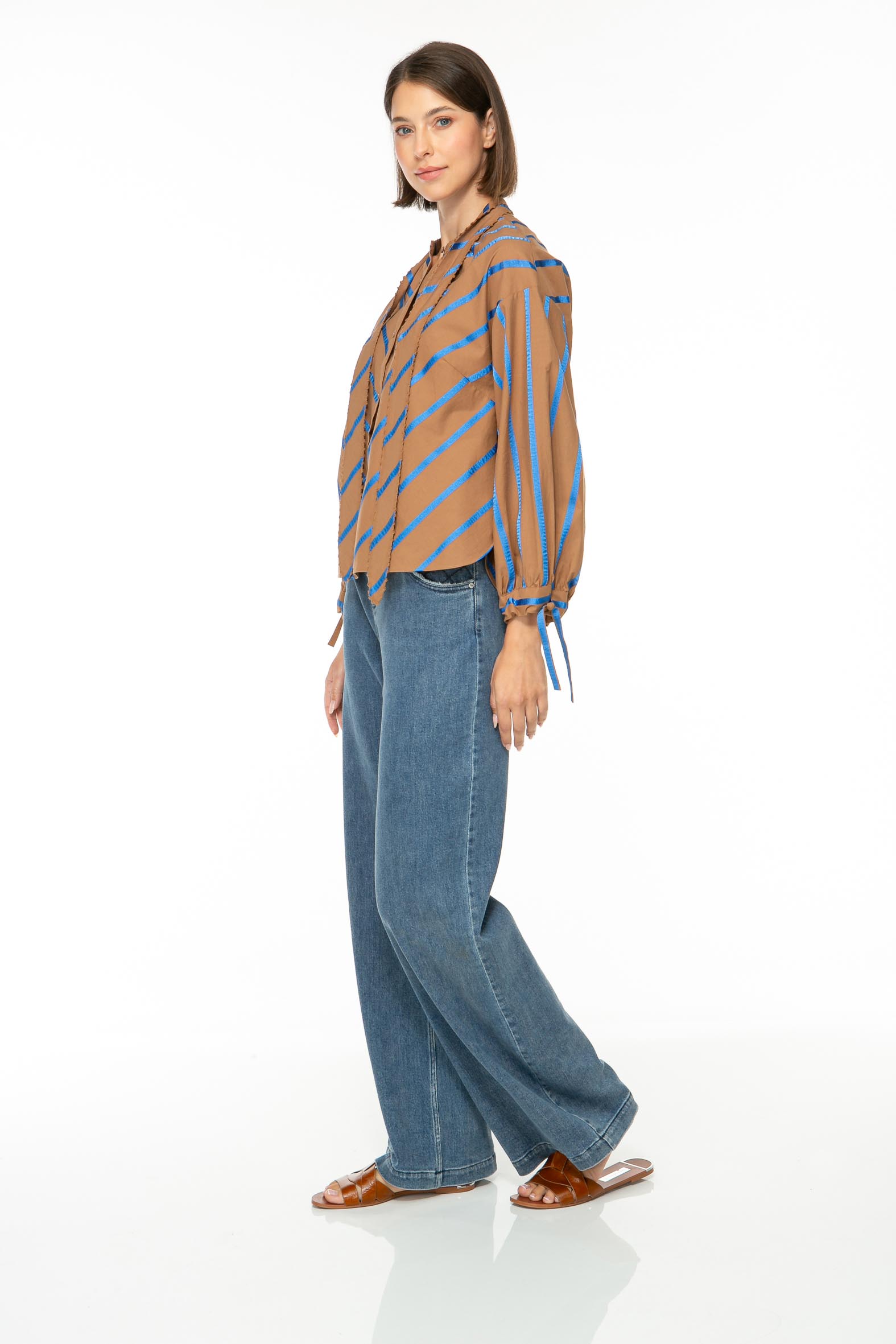 M35_2889 Produktbild: ROYAL STRIPE Baumwollbluse mit blauen Streifen auf dunkelbraunem Hintergrund. Bild von der Seite.